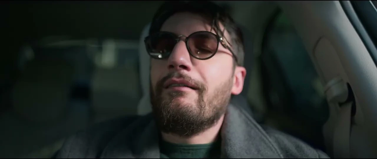 A man wearing sunglasses inside a car