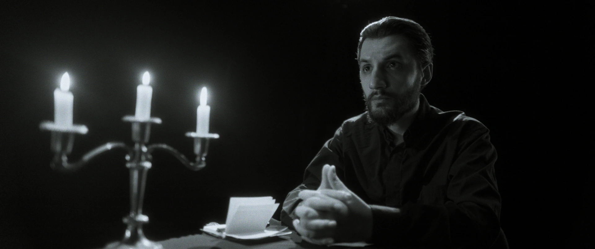 Candlelit monochrome scene from Kripë dhe Sheqer